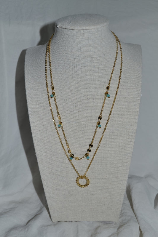 Collier double chaîne dorée avec pendentif soleil et pierre bleue