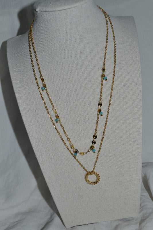 Collier double chaîne dorée avec pendentif soleil et pierre bleue